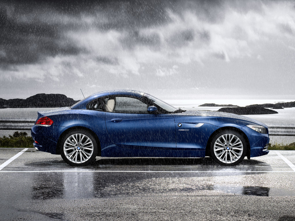 Mavi BMW Z4 E89 katlanır metal tavan kapalıyken yağmurda yan profil
