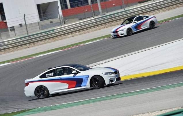 İki BMW M4 Coupe pistte yan profilden
