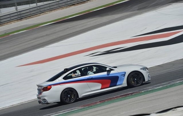 Beyaz BMW M4 Coupe pistte arka yan görünüm