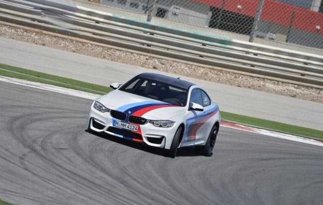 Beyaz BMW M4 Coupe viraj girişinde