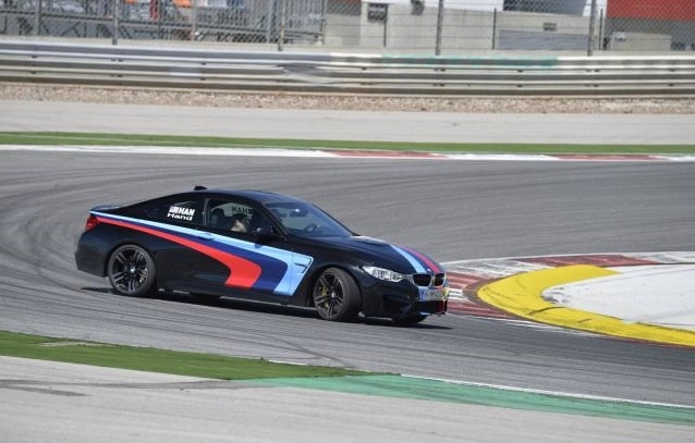 Siyah BMW M4 Coupe virajda yan görünüm