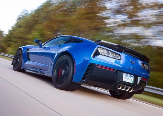 Mavi Corvette Z06 hareket hâlinde arka üç çeyrek görünümü