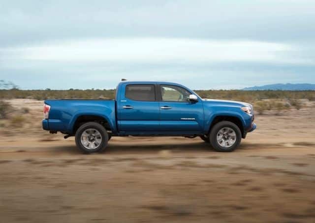 Toyota Tacoma mavi Double Cab yandan hareket görünümü
