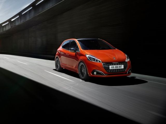 Peugeot 208 turuncu gövdeyle önden üç çeyrek sürüş görünümü