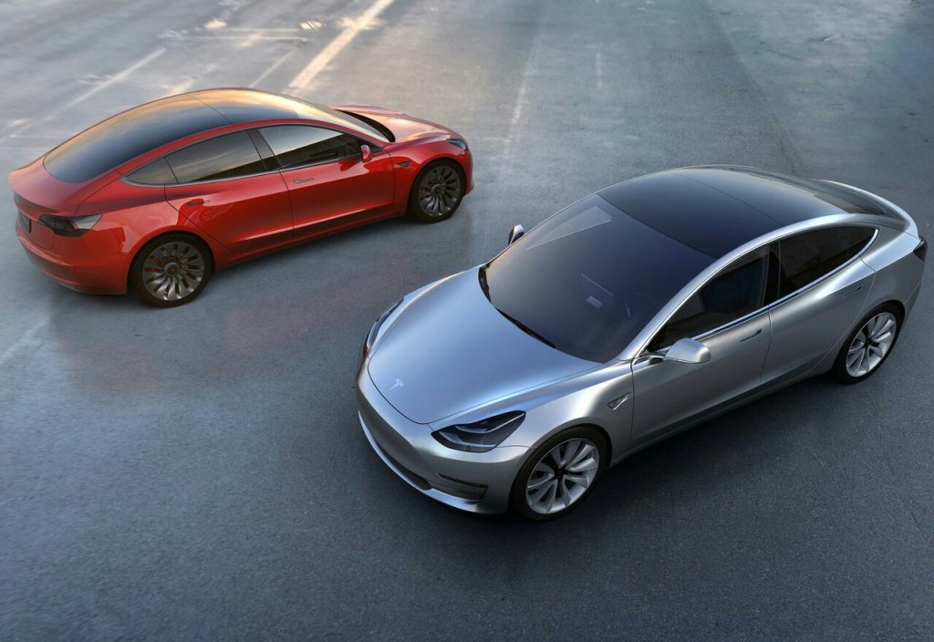 Kırmızı ve gümüş Tesla Model 3 araçları üst açıdan