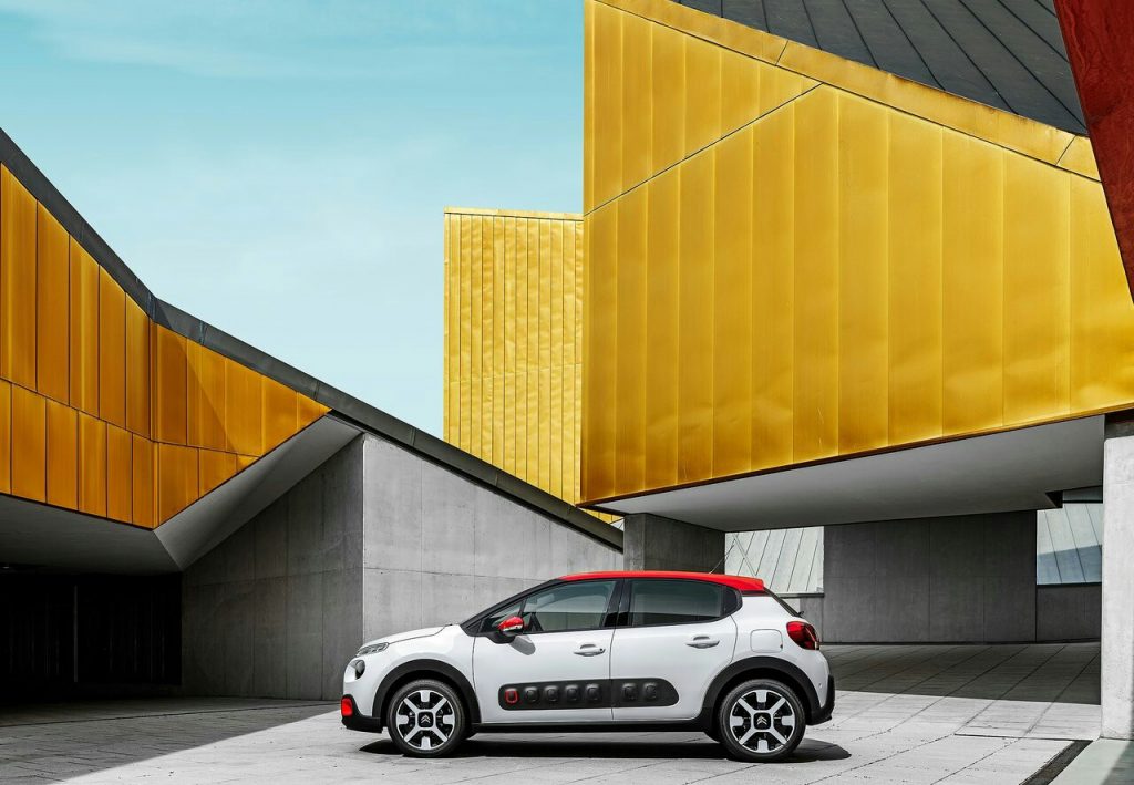 Citroen C3 beyaz gövde kırmızı tavan yan profil mimari fonda