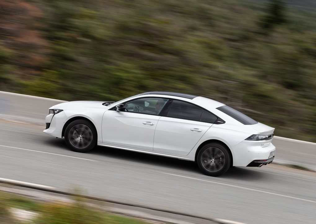Yolda ilerleyen beyaz Peugeot 508 arka yan görünümü