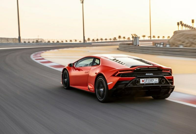 Turuncu Huracan EVO pistte arkadan üç çeyrek sürüş görünümü