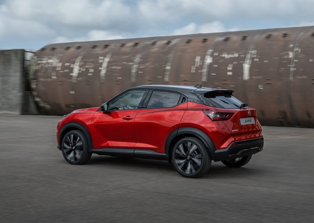 Hareket halindeki kırmızı Nissan Juke arka üç çeyrek görünümü