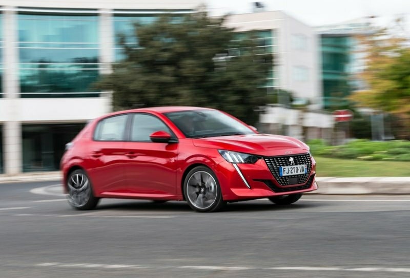 Şehir yolunda hareket halindeki kırmızı Peugeot 208
