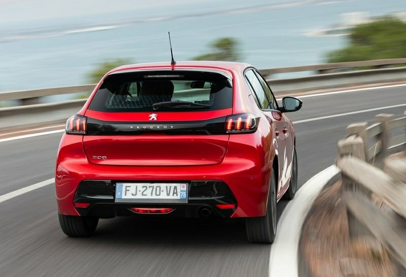 Yolda ilerleyen kırmızı Peugeot 208 arkadan görünümü