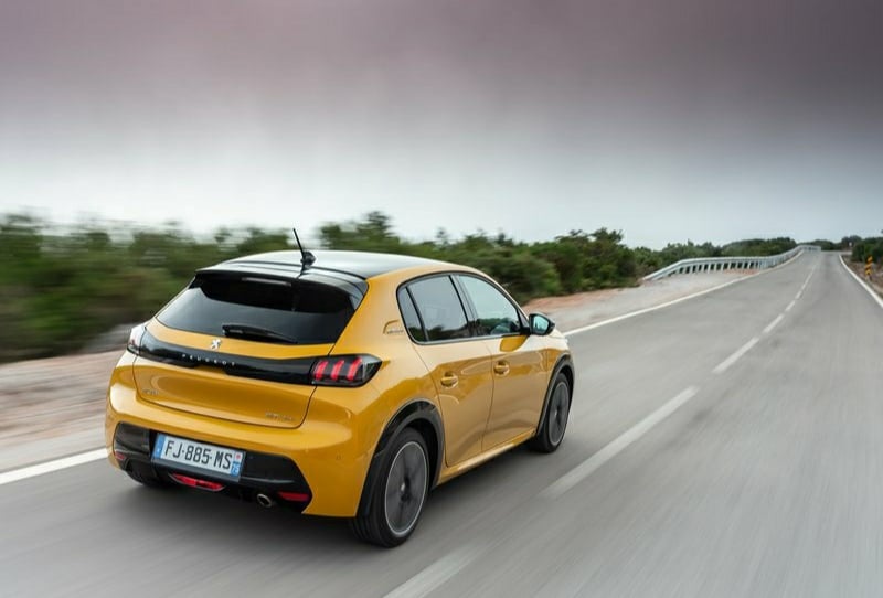 Otoyolda ilerleyen sarı Peugeot 208 arka görünümü