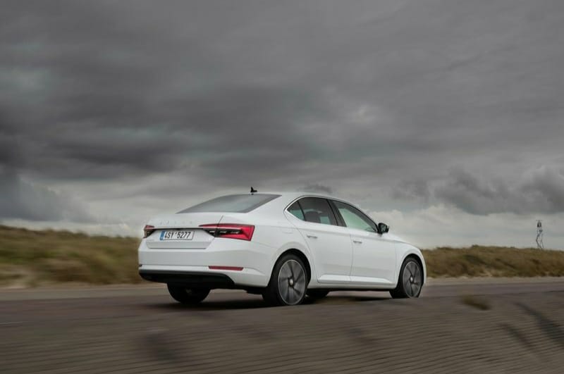 Beyaz Skoda Superb açık yolda arka yan görünümü