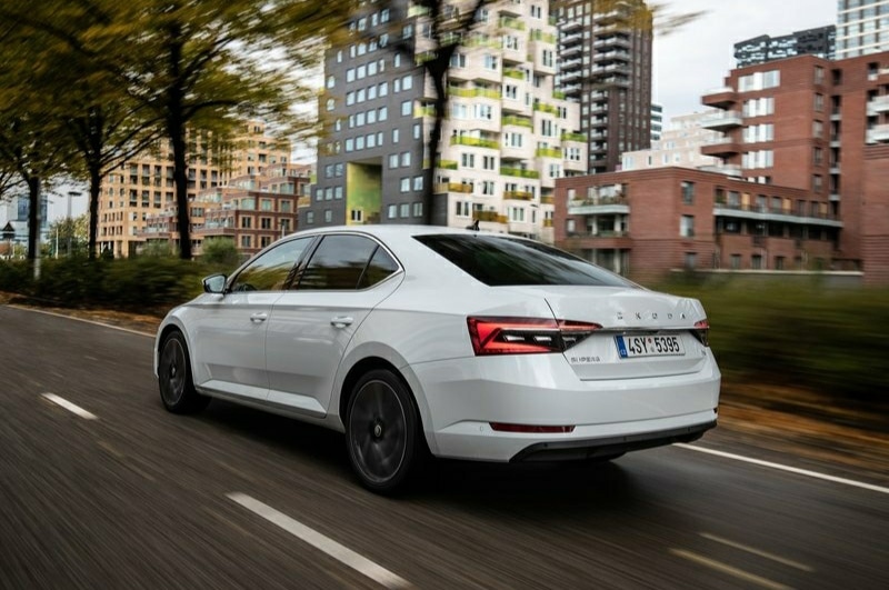 Beyaz Skoda Superb şehir yolunda arka gövde görünümü