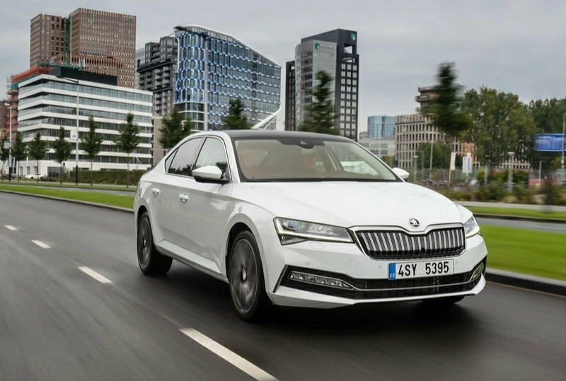 Beyaz Skoda Superb şehir yolunda ön gövde görünümü