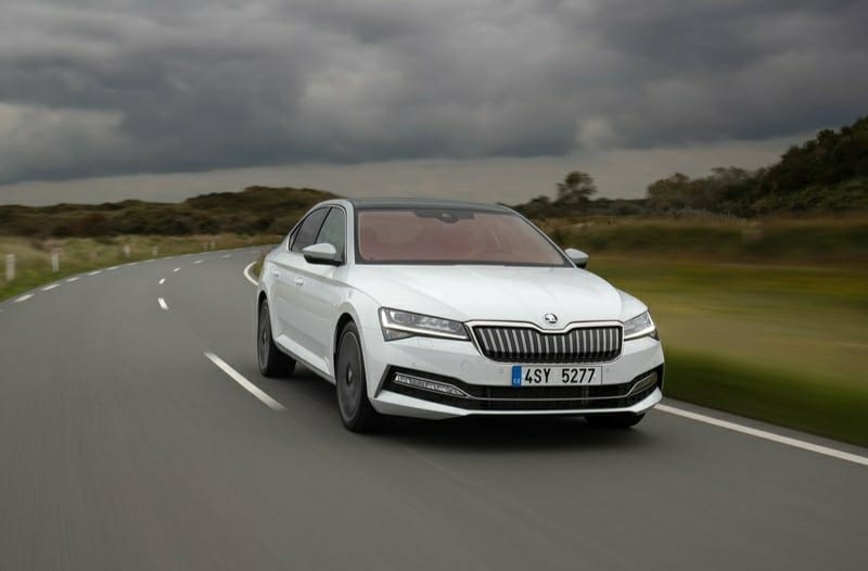 Beyaz Skoda Superb yolda ilerlerken ön gövde görünümü