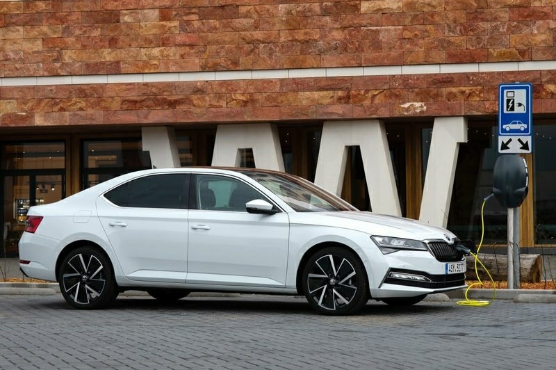 Beyaz Skoda Superb park alanında yan profil görünümü
