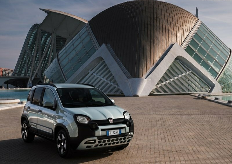 Fiat Panda Hybrid açık renk gövdeyle şehir mimarisi önünde