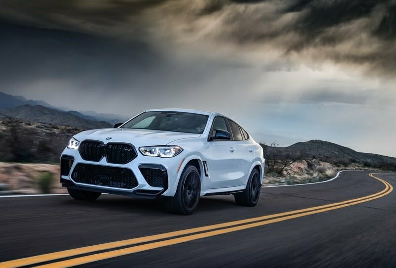 Beyaz BMW X6 M Competition hareket halinde ön görünümü