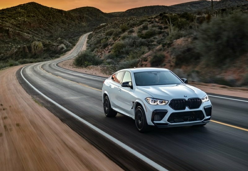 Beyaz BMW X6 M Competition yolda ön görünümü