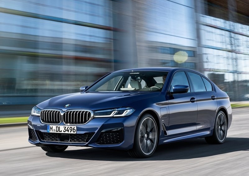 Mavi BMW 5 Serisi sedan şehir yolunda ön görünümü