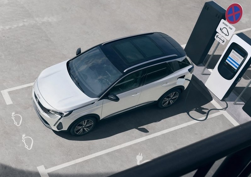 Beyaz Peugeot 3008 şarj noktasında üstten görünüm
