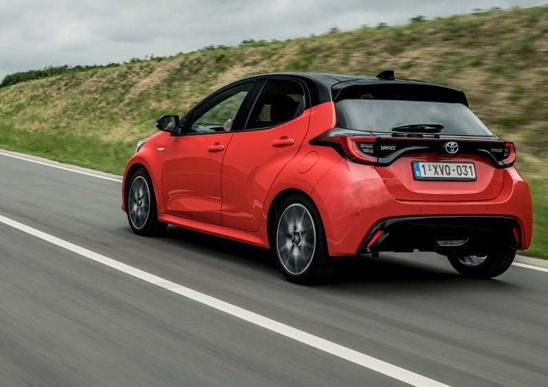 Kırmızı Toyota Yaris yolda arka üç çeyrek görünümü