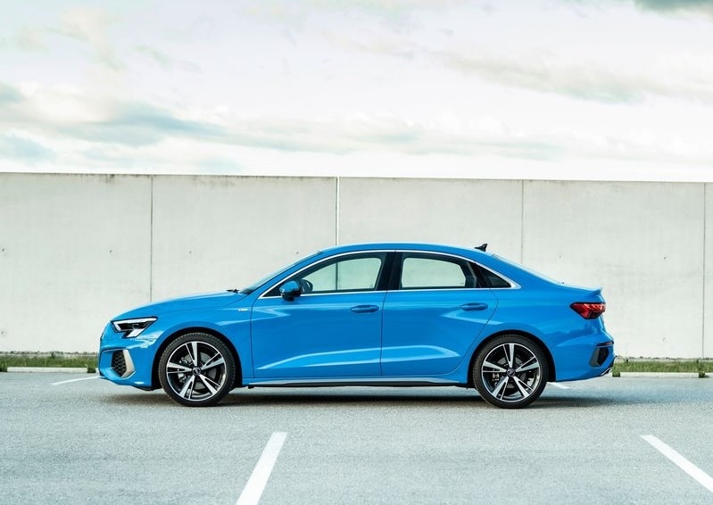 Mavi Audi A3 Sedan beyaz duvar önünde tam yan profil görünümü