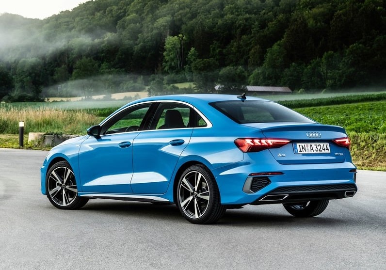 Mavi Audi A3 Sedan yeşil alan önünde arka ve yan gövde görünümü