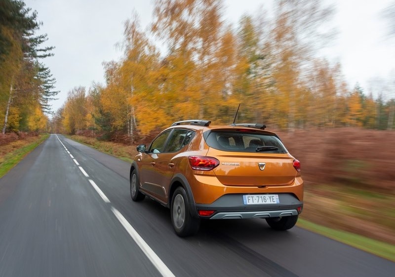Turuncu Dacia Sandero Stepway arkadan üç çeyrek yol görünümü