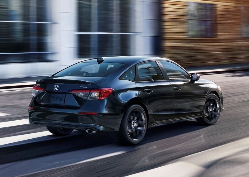 Koyu renk Honda Civic sedan hareket halinde arka yan görünümü