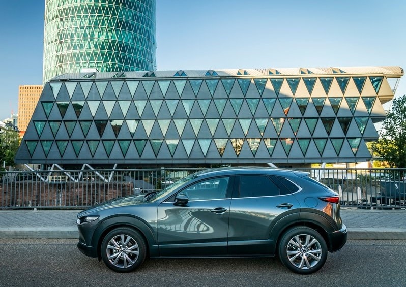 Mazda CX-30 şehir mimarisi önünde yan profil