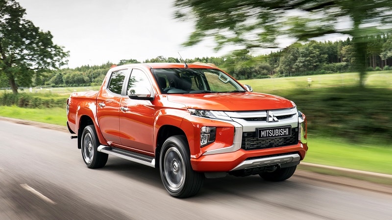 Turuncu Mitsubishi L200 asfalt yolda hareket halinde