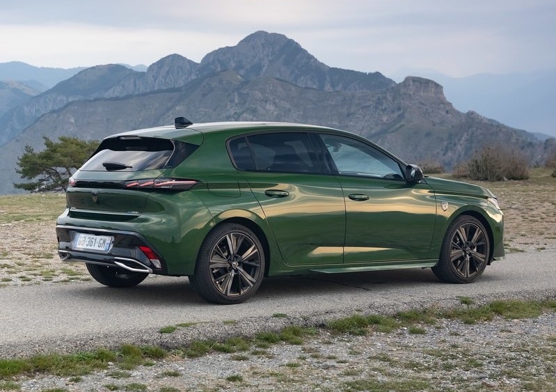 Yeşil Peugeot 308 dağ manzarası önünde yan ve arka gövde görünümü