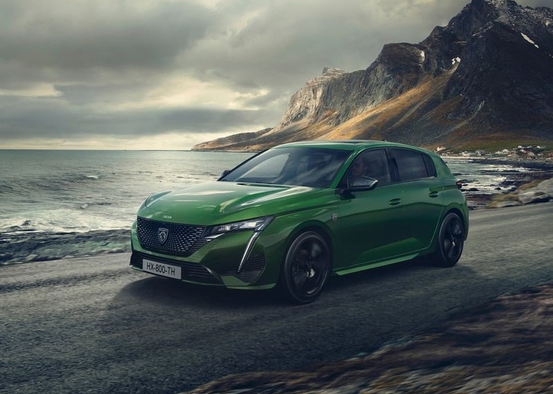 Yeşil Peugeot 308 kıyı yolunda ön yan gövde görünümü