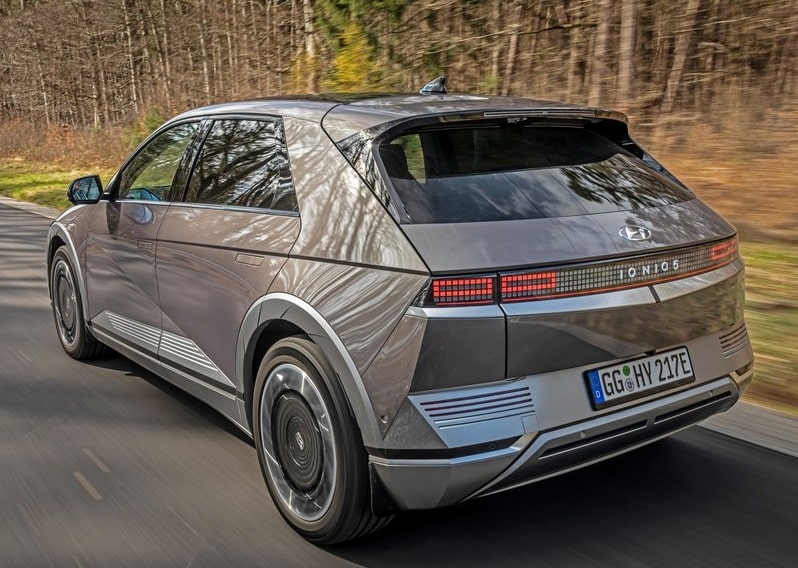 Koyu gri IONIQ 5 hareket halinde arka üç çeyrek görünüm