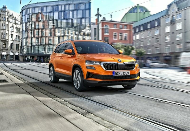 Turuncu Skoda Karoq şehir yolunda ön üç çeyrek görünüm