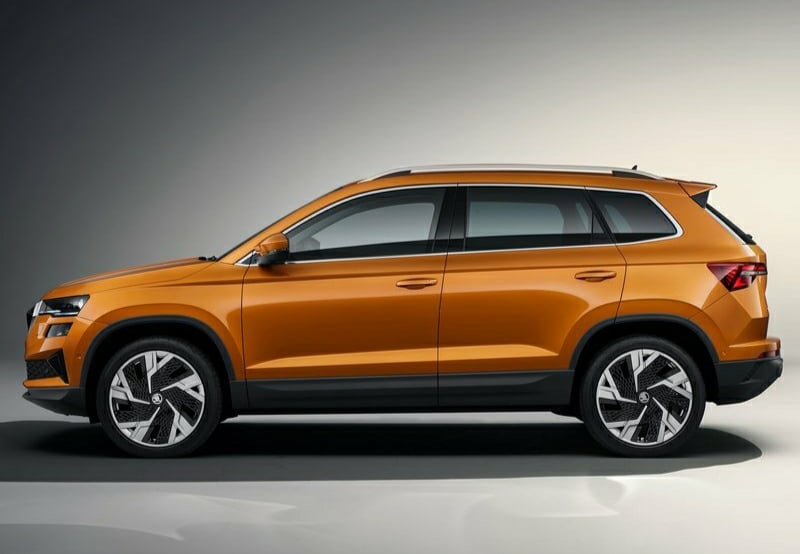 Turuncu Skoda Karoq stüdyo ortamında yan profil görünümü