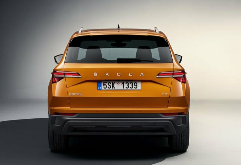 Turuncu Skoda Karoq stüdyo ortamında doğrudan arka görünüm