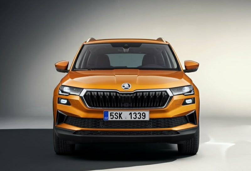 Turuncu Skoda Karoq stüdyo ortamında doğrudan ön görünüm