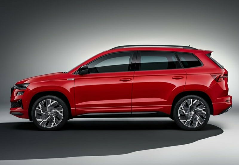 Kırmızı Skoda Karoq stüdyo ortamında yan profil görünümü