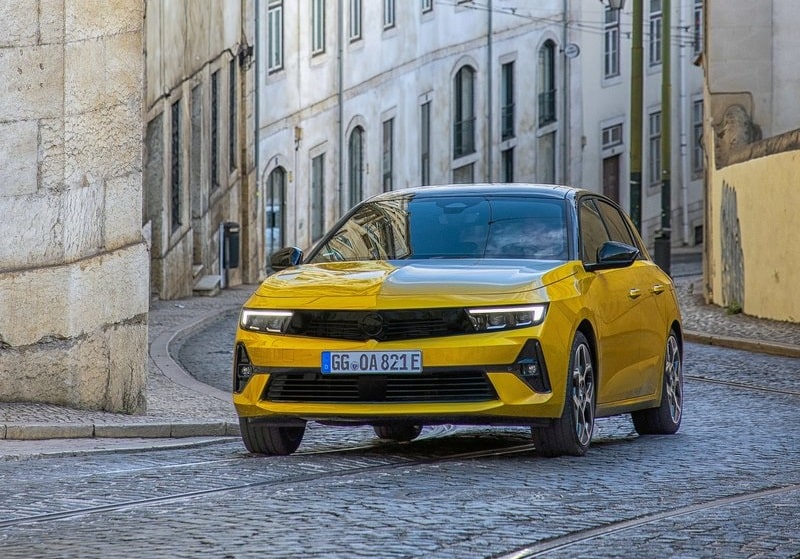 Sarı Opel Astra şehir sokağında önden görünüm