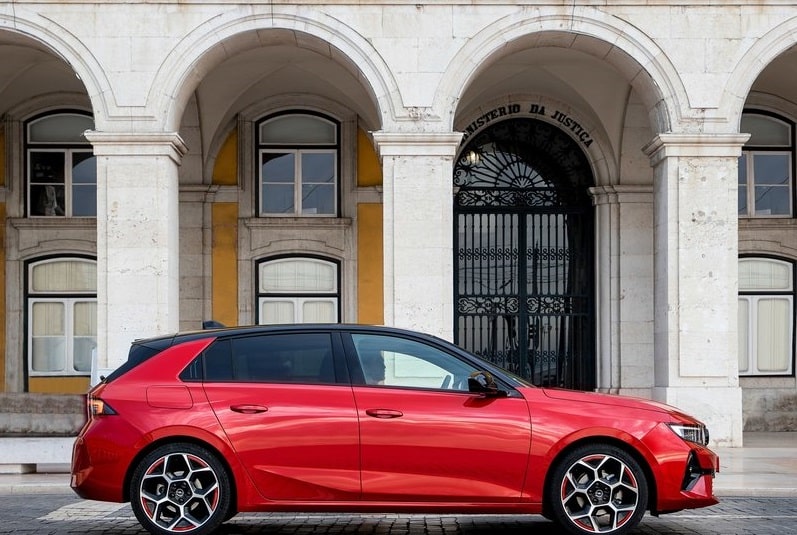 Kırmızı Opel Astra tarihi yapı önünde yan profil
