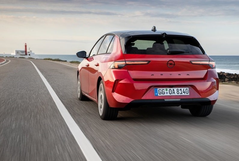 Kırmızı Opel Astra kıyı yolunda hareket halinde arkadan görünüm