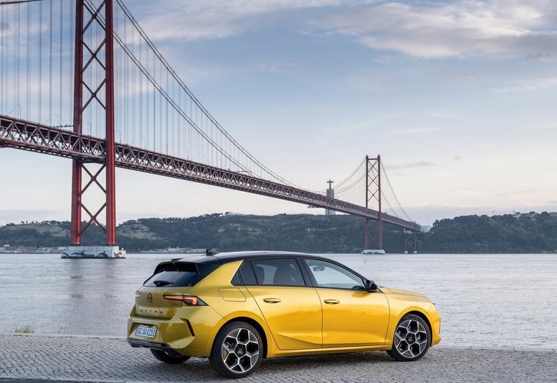 Sarı Opel Astra köprü kıyısında arka üç çeyrek görünümü