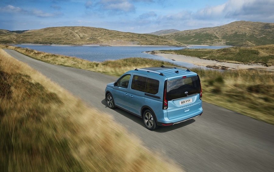 Mavi Ford Tourneo Connect göl kıyısındaki yolda hareket halinde