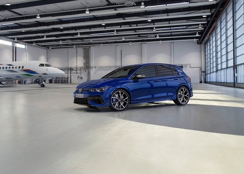 Hangar içinde mavi Volkswagen Golf R ön üç çeyrek görünümü