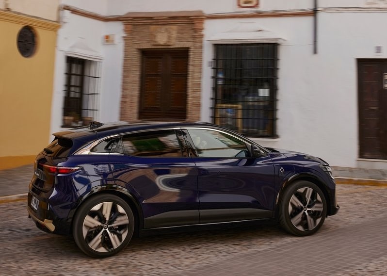 Lacivert Renault Megane E-Tech taş döşeli şehir yolunda yan görünüm