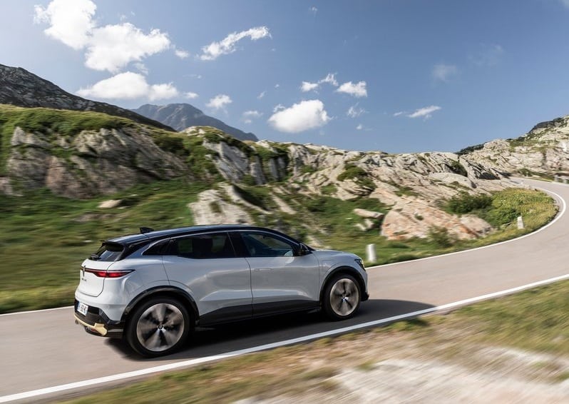 Renault Megane E-Tech dağ yolunda arka yan hareket görünümü