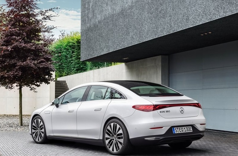 Beyaz Mercedes-Benz EQE sedanın konut önünde arka üç çeyrek görünümü